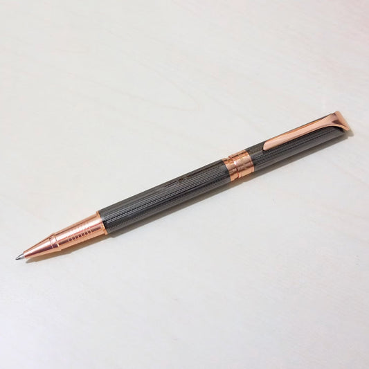 Pen with rose gold accents on a light gray background