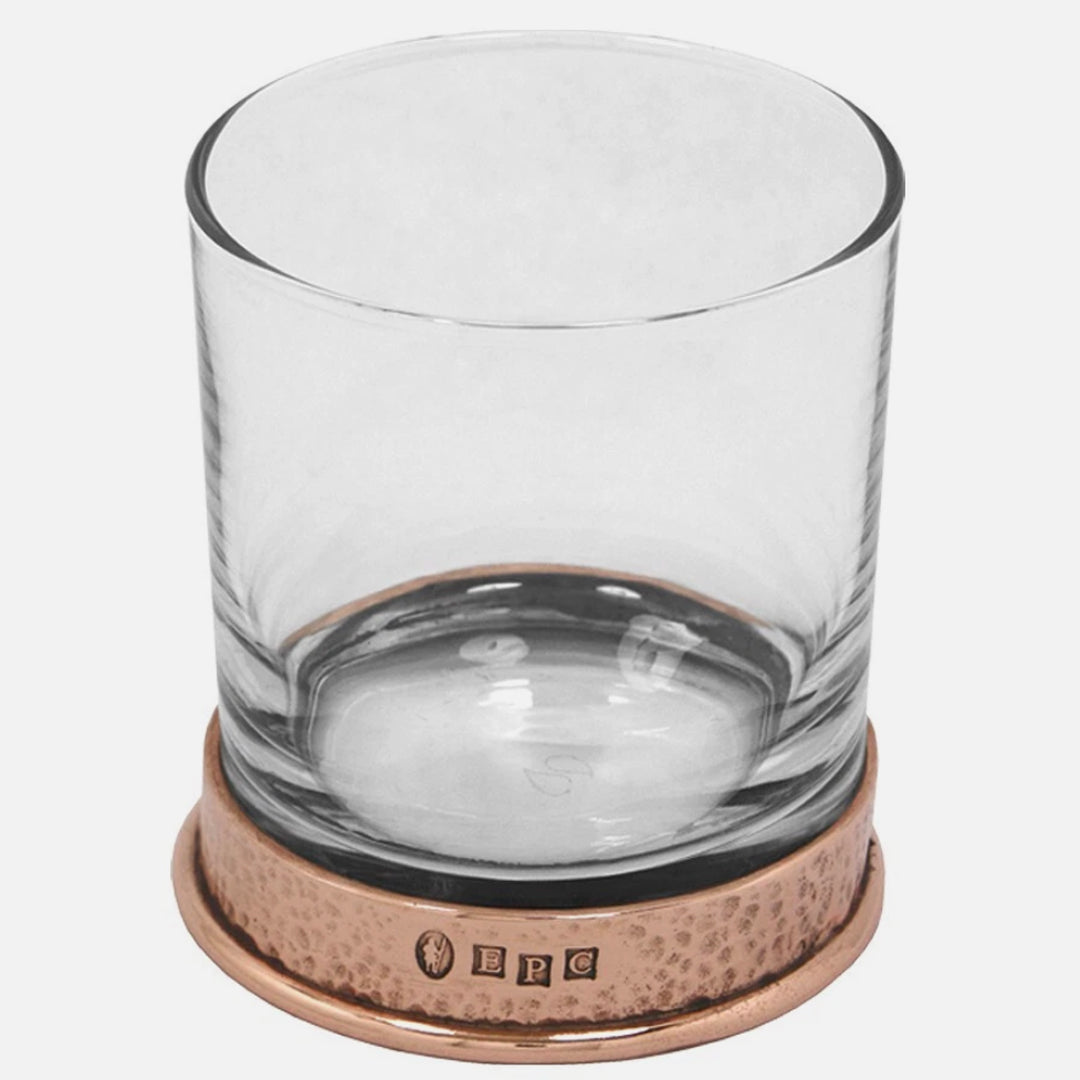 Clear glass tumbler with a copper base on a white background