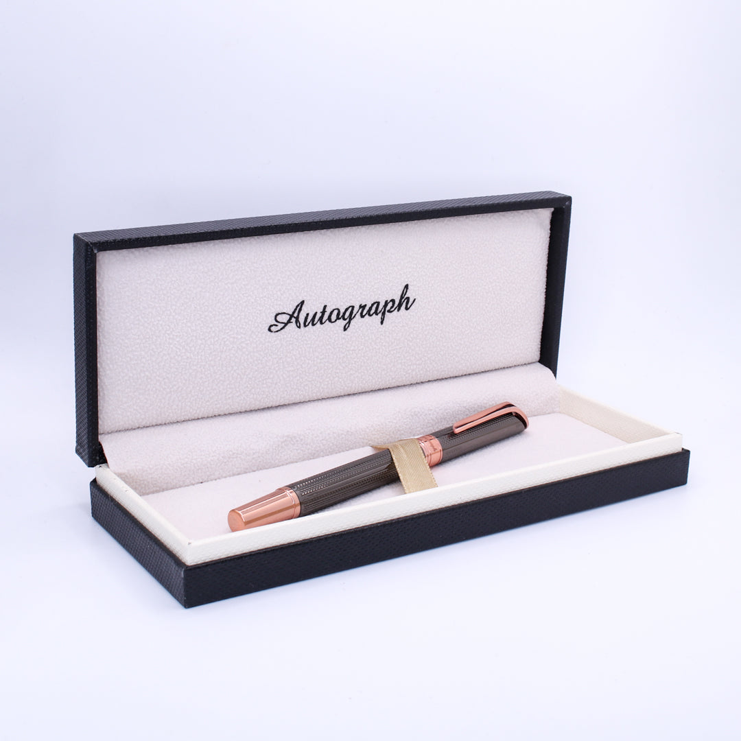 Fountain pen in a black and rose gold box with 'Autograph' branding on a light purple background.