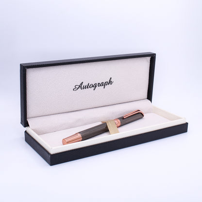 Fountain pen in a black and rose gold box with 'Autograph' branding on a light purple background.