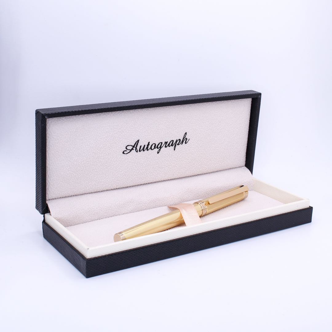 Gold pen in a black and beige 'Autograph' box on a white background