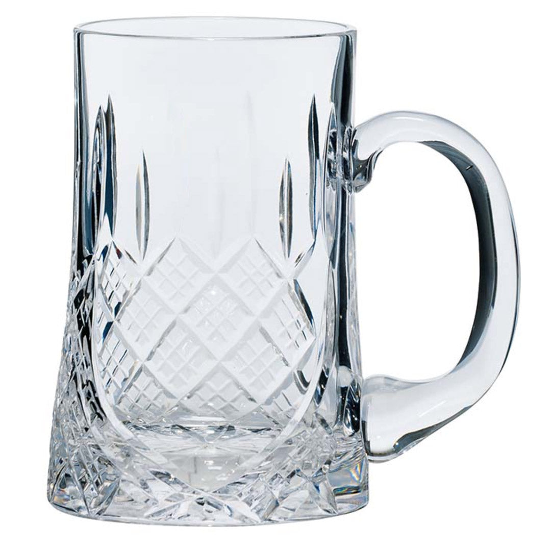 Clear glass tankard with intricate cut patterns on a white background