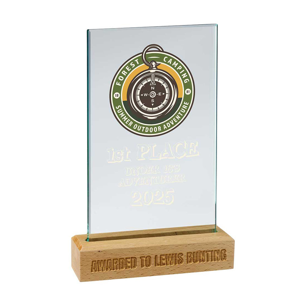 Glass award with wooden base featuring a compass design and text on a white background