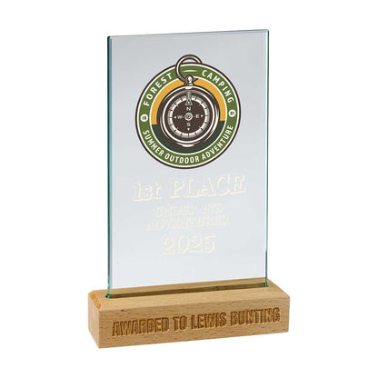 Glass award with wooden base featuring a compass design and text on a white background