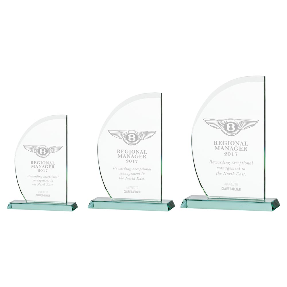 Three glass awards with engraved text on a white background