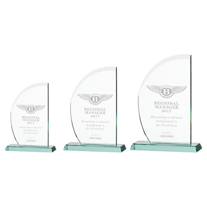 Three glass awards with engraved text on a white background