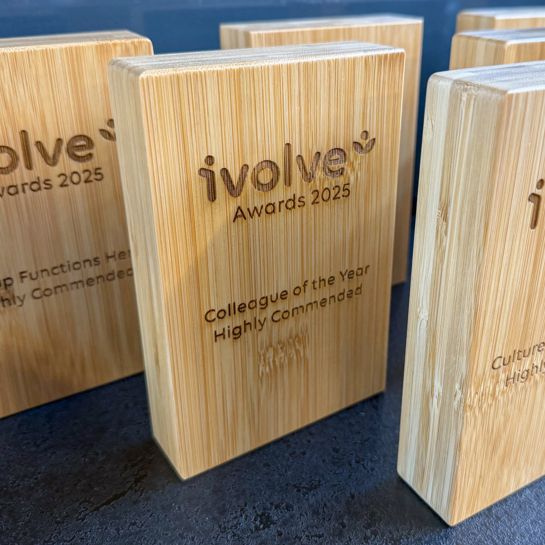Wooden awards with 'ivolve Awards 2025' text on a blue background